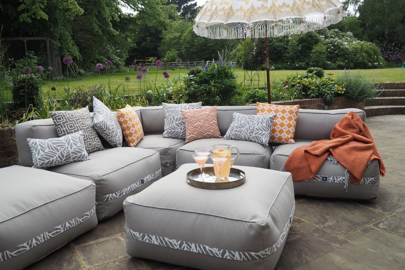 A soft comfortable garden sofa is laid out ready for a garden party