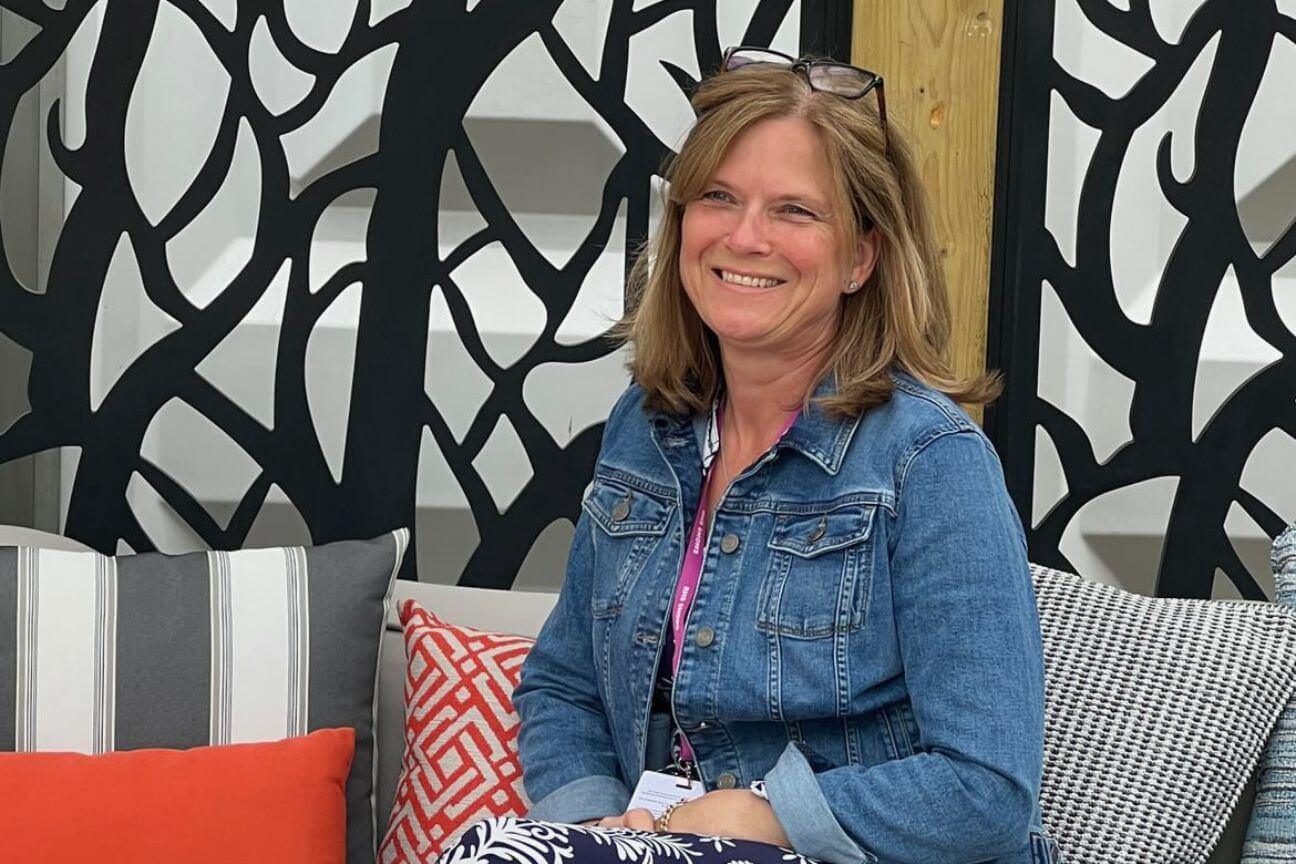 Caroline Lomax, Founder of Armadillo Sun, sat smiling on one of the garden sofas she creates.