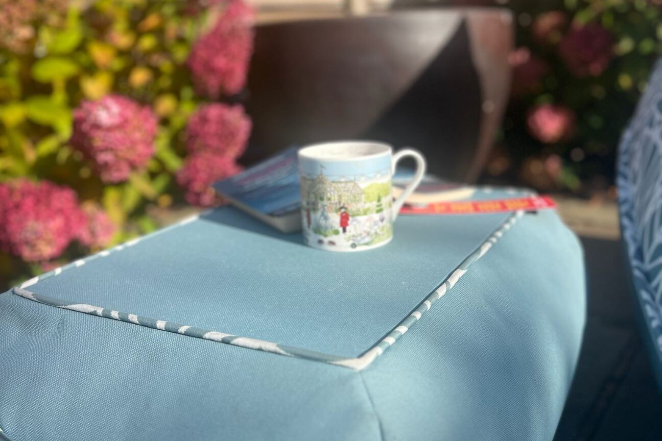 A low garden table with a cup of tea and book in the winter sunshine.