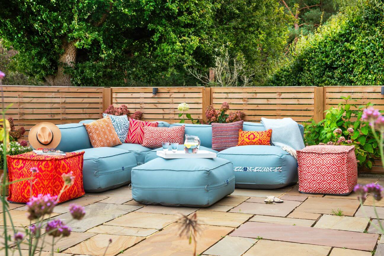 Light blue garden sofa with outdoor cushions outside on a patio.