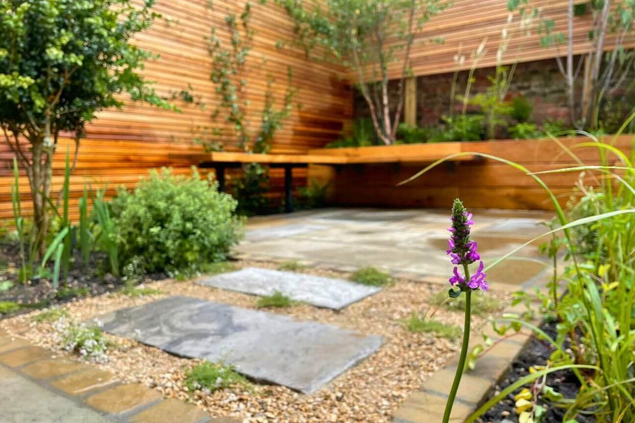 A low maintenance garden designed by Jake Sutcliffe featuring gravel, large slabs, and resilient planting.