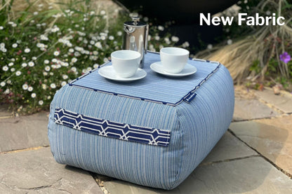 indoor and out bean bag table in pinstripe navy with calypso handles on a stone patio with outdoor setting