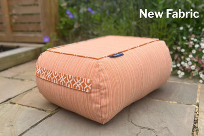 indoor and out bean bag  in orange pinstripe with calypso patterned handles on a stone patio