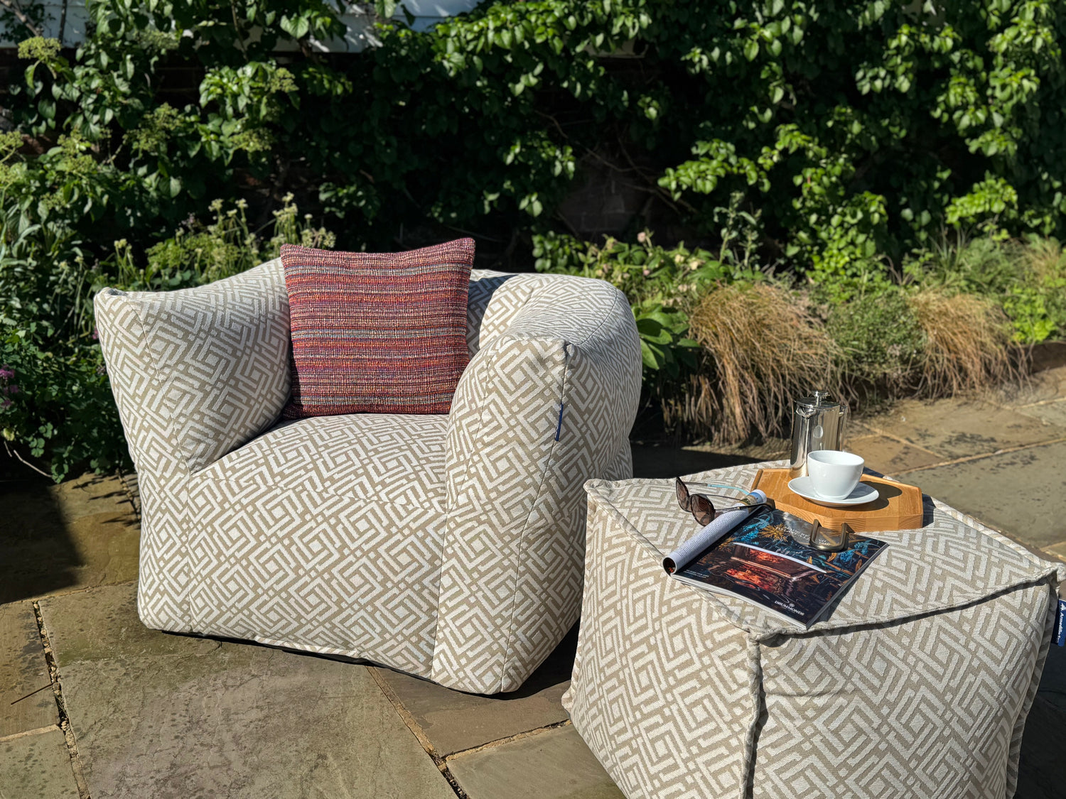 garden bean bag armchair in natural sigma geometric style with matching garden bean bag pouffe and outdoor woven cushion in tropic red and purple