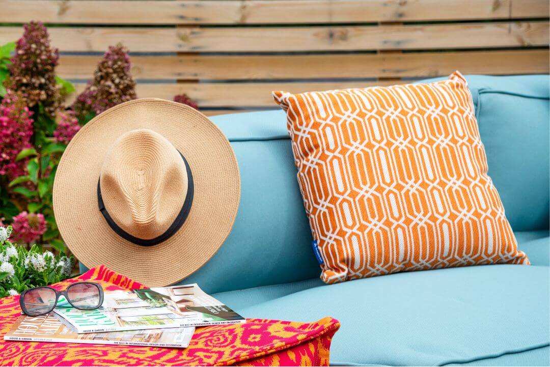 Orange and white patterned garden cushion on outdoor sofa.